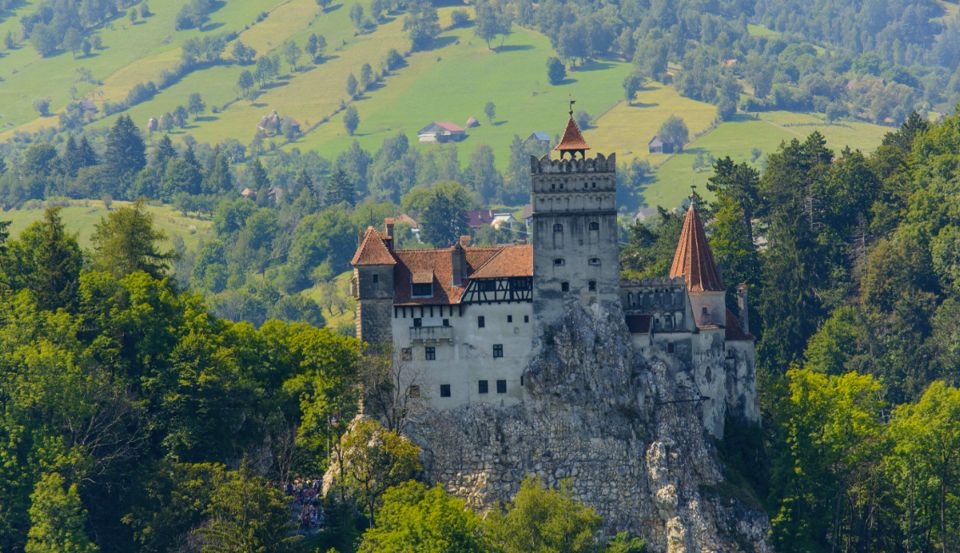 Bran Castle on its rocky hill, surrounded by wooded countryside