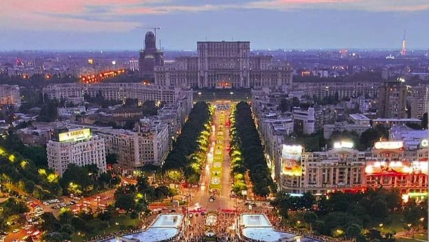Bucharest at dusk, with the Palace of the Parliament at the end of the boulevard