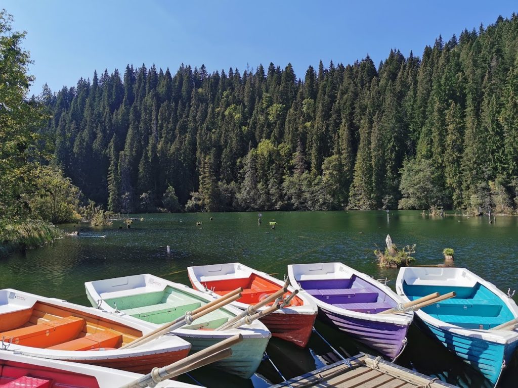 Colourful rowing boats beside the forested shore of Lacul Roșu